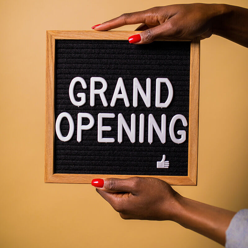 person holding Grand Opening sign